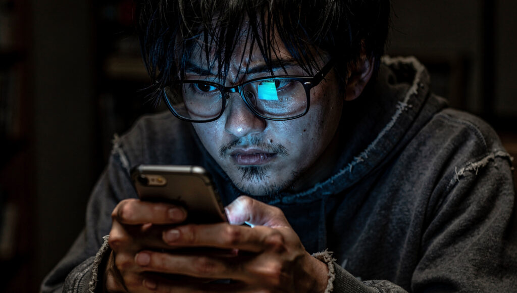 LINEグループを見つめる男性