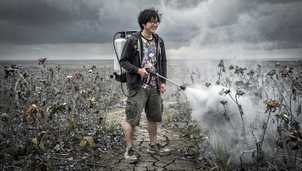 強力な除草剤を撒き散らしている男性