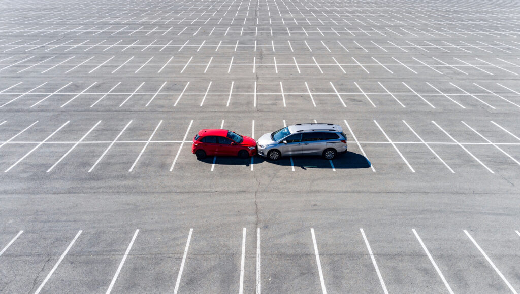 赤い車の隣に停めたトナラーの車